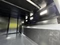 A 2012 Freightliner M2 106 truck interior featuring a flat black surface with built-in lighting and spacious compartment design