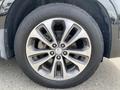 Close-up of a silver alloy wheel from a 2015 Kia Sorento featuring a unique five-spoke design and a dark tire with the brand name visible