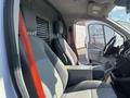 Interior of a 2016 Ford Transit showing two front seats with grey upholstery and a dashboard featuring controls and a steering wheel