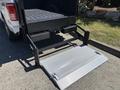 A 2016 Ford F-150 with a retractable loading ramp extending from the truck bed for easy access to the cargo area