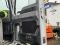 A 2023 Mack Granite truck door with a sleek design featuring a large handle and various buttons for controls