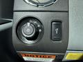 Close-up of a control panel in a 2016 Ford F-550 featuring a dial for headlights and various light settings with a warning label below