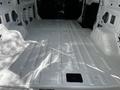 A 2021 Ford Transit van with an empty white cargo area featuring smooth, flat surfaces and no installed shelving or partitions