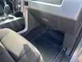 Interior view of a 2014 Ford F-150 showing the driver seat floor space and center console with a gear shift and storage compartments