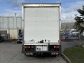 A 2014 Hino 195 truck is parked with its back facing the viewer featuring a plain white cargo area and visible brake lights