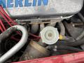 Close-up of the engine components of a 1970 Chevrolet Corvette featuring a silver cylinder head with red wiring and a metal valve with yellow markings