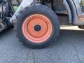 Close-up of a tire from a 2015 Bobcat 5600 featuring a thick tread and distinctive orange wheel rim