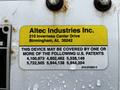 A close-up of a yellow and white label featuring the name Altec Industries Inc and various U.S. patents with a list of numbers and a cautionary note about patent coverage