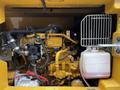 A close-up view of the engine compartment of a 2024 Caterpillar 306 showcasing its internal components and yellow-colored parts