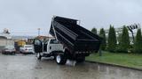 A 2021 International CV515 truck with its dump bed raised and open, showcasing the cargo area designed for hauling materials