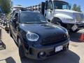 A black 2022 Mini Countryman with a sporty design and distinct grille features in the foreground