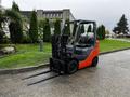 A 2017 Toyota 8FCGCU25 forklift with an orange and gray design featuring two long forks in front and a black seat for the operator