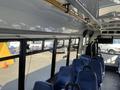 Interior view of a 2017 Chevrolet Express with blue padded seats and large windows along the sides