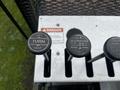 A set of three control levers labeled for turning left and right and telescoping, mounted on a metal panel