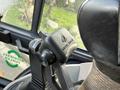 Close-up of the control lever on a 2005 Case 570 equipment cab showing the brand logo and part of the seat upholstery