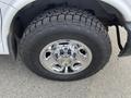 Close-up of a chrome wheel and tire on a 2012 GMC Savana featuring an open country all-terrain tire tread pattern