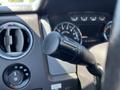 Close-up of a 2014 Ford F-150 steering column showing the gear shift lever and dashboard controls