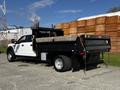 A 2021 Ford F-550 pickup truck with a flatbed and wooden sides parked in a warehouse area