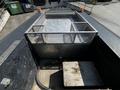 A metal cage with a mesh design is mounted on the flatbed of a 2008 Ford F-550 truck with wooden flooring and a hatch cover inside the cage