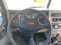 The interior view of a 2008 Peterbilt 340 showing the steering wheel with the Peterbilt logo and various dashboard gauges and controls