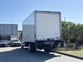 A 2015 Freightliner M2 106 box truck with a white cargo area and red and white rear bumper parked in a lot