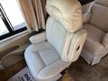 A beige leather captain's chair with a high back and armrests in a 2000 Ford Motorhome's interior