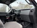 Interior of a 2013 Ford F-650 featuring a dashboard with control buttons and a gear shift alongside a driver's seat