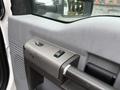 Interior door handle and control panel of a 2012 Ford F-550 featuring switches for locks and windows