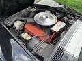 Engine compartment of a 1972 Chevrolet Corvette featuring a large polished air cleaner silver components and red engine block with various mechanical parts visible