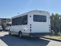 A white 2017 Chevrolet Express bus with large windows and a rear loading area parked in a lot