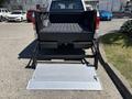 A 2016 Ford F-150 with its tailgate down and a loading ramp extended from the truck bed