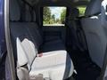 Interior view of a 2014 Ford F-250 SD showing the backseat with gray fabric upholstery and two rows of seats
