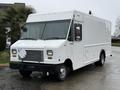A white 2012 Ford Econoline van with a large boxy shape and multiple front windows