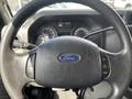Close-up of the steering wheel of a 2009 Ford Econoline featuring the Ford logo and control buttons on the wheel
