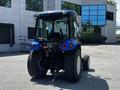 A blue 2018 New Holland Boomer 45 tractor with a cab and large rear tires is parked in an outdoor setting without any attachments visible