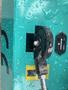 Close-up of a control mechanism on a turquoise 2024 AGT Industrial MH12R Mini Excavator with water droplets on the surface
