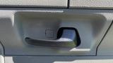 Close-up of a black door handle on a 2013 Ford Econoline with a textured gray panel surrounding it