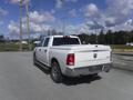 A white 2019 RAM 1500 Classic Eco Diesel is parked with its rear facing the viewer showcasing its truck bed and dual exhaust pipes