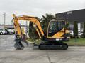 A yellow and black 2022 Hyundai R55-9A compact excavator with a boom arm and bucket attachment facing right