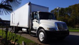 A 2008 International 4300 truck with a white boxy cargo area and a prominent front grille parked at an angle with large tires and side mirrors visible
