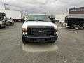A 2010 Ford F-250 SD with a white exterior and black grille facing forward with no visible cargo in the bed