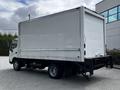 A 2018 Hino 195 box truck with a large white cargo area and a black chassis parked at an angle showing its side and rear views