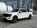 A white 2021 Ford F-150 with black accents parked on a street showing its sleek design and modern features