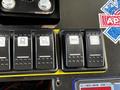 Control switches for a 2013 Chevrolet Express featuring icons for lighting functions such as fog lights and spotlights