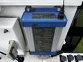 A blue electronic control box with various labels and a cable connection mounted on a white surface
