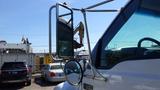 A 2006 Ford F-650 truck with a large side mirror and a reflective surface showing part of the truck's body and window