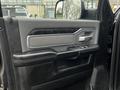 Interior view of a 2020 RAM 3500 driver's side door panel featuring controls for windows and locks with a textured surface and a chrome handle