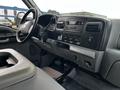 Interior of a 2007 Ford F-550 showing the dashboard with controls and instruments along with the gear shift and cup holder