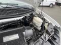 A close-up view of the engine components of a 2016 Chevrolet Express showing the air filter housing and brake fluid reservoir
