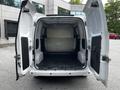The interior of a 2020 Nissan NV200 cargo van with open rear doors showcasing a spacious empty cargo area
